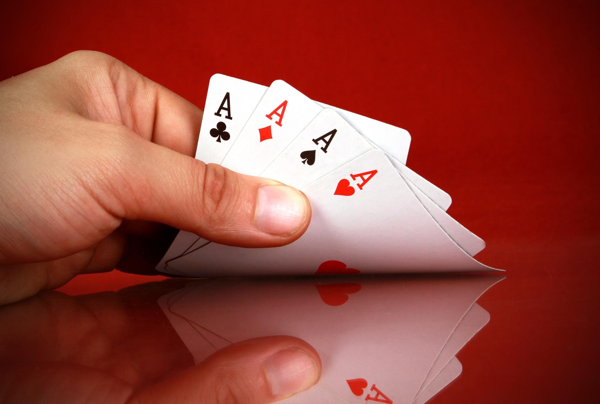 person-playing-cards-with-four-kind-hand